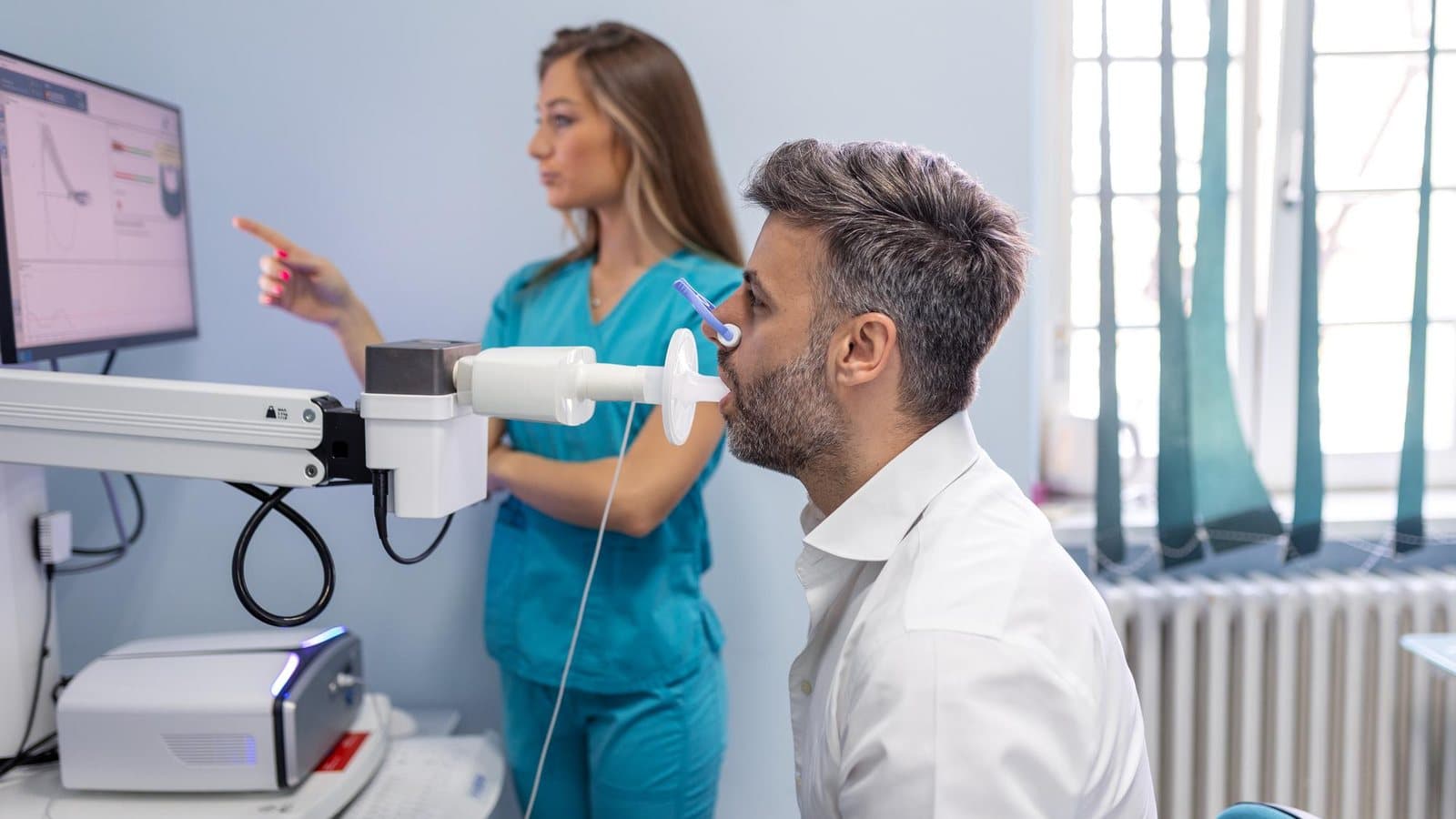 Profissional de saúde orienta paciente durante o exame de espirometria